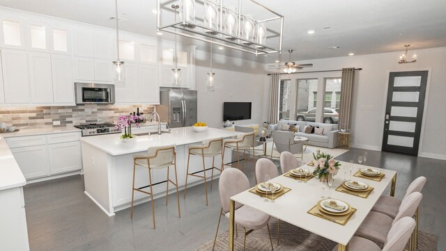dining area featuring dark hardwood / wood-style flooring, sink, and ceiling fan with notable chandelier