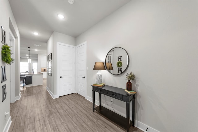 hallway with light wood-type flooring and sink