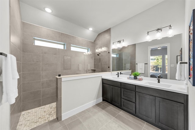 bathroom featuring vanity, tile patterned flooring, and tiled shower