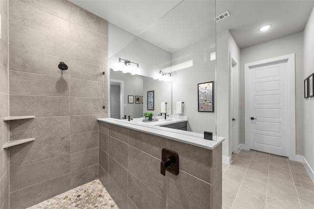 bathroom featuring vanity, tile patterned flooring, and tiled shower