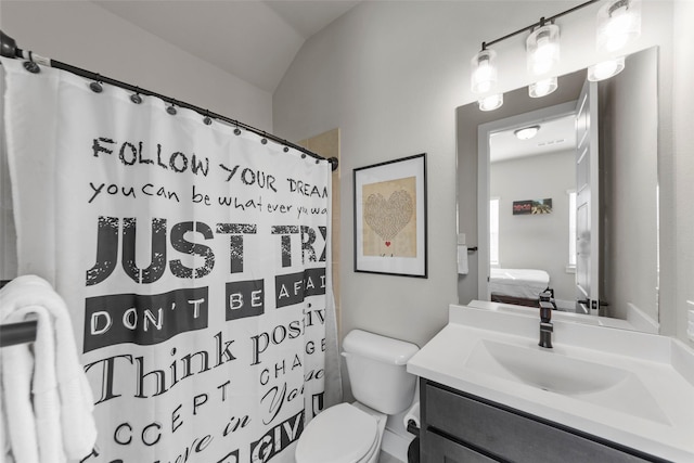 bathroom featuring lofted ceiling, vanity, toilet, and walk in shower