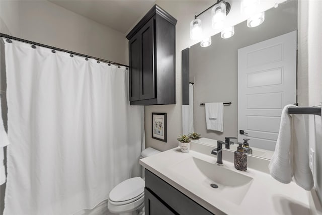 bathroom with toilet, vanity, and walk in shower