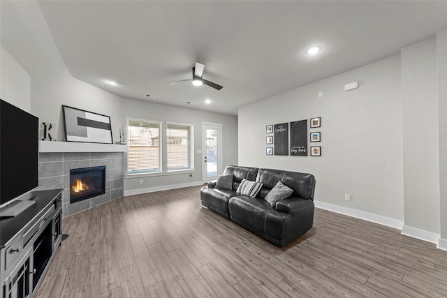 living room with hardwood / wood-style flooring, ceiling fan, and a fireplace