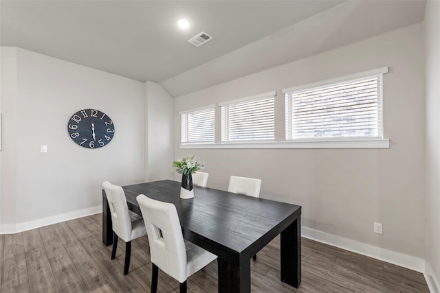 dining area with hardwood / wood-style flooring and vaulted ceiling