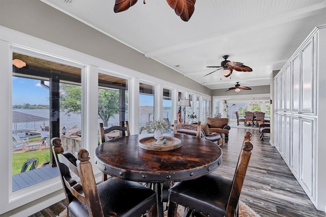 dining room featuring a water view, beam ceiling, ceiling fan, and dark hardwood / wood-style flooring