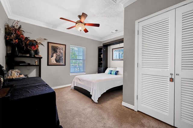 bedroom with ceiling fan, carpet flooring, crown molding, and a textured ceiling