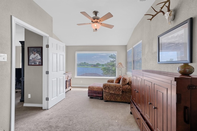 living area featuring ceiling fan, light colored carpet, vaulted ceiling, and a wealth of natural light