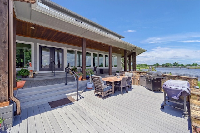 deck featuring a water view, grilling area, and french doors