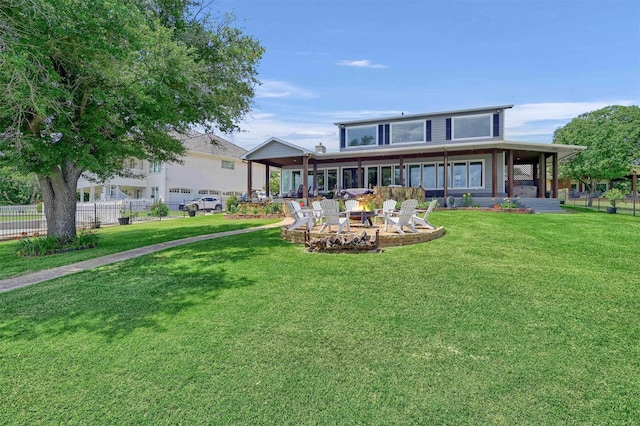 back of property featuring an outdoor fire pit and a lawn