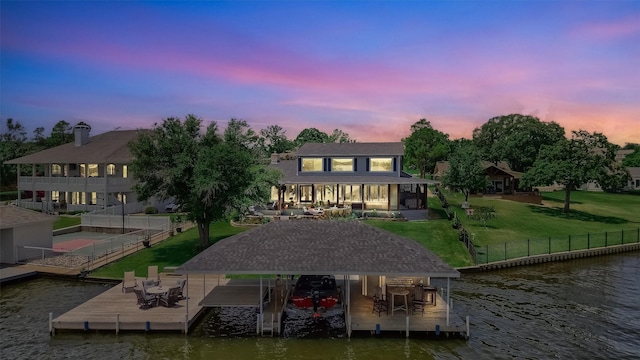 view of dock with a water view and a lawn