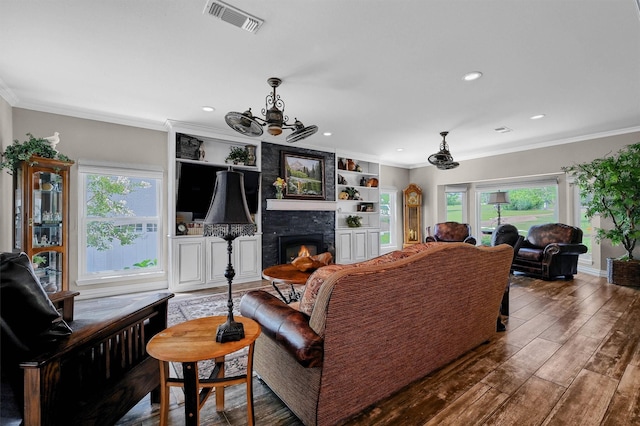 living room with crown molding and a fireplace