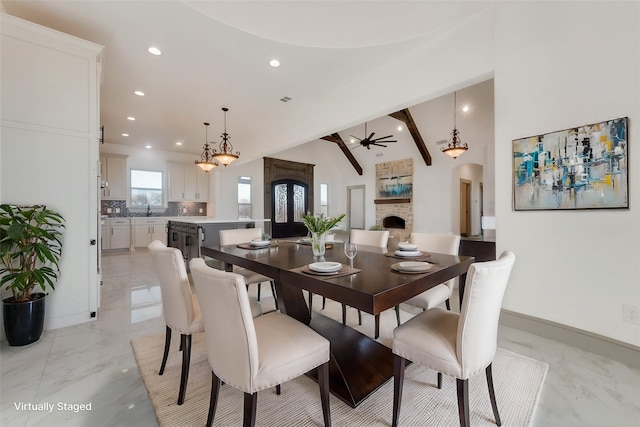 dining room with ceiling fan, sink, and vaulted ceiling with beams