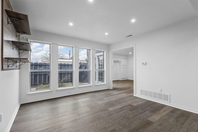 unfurnished living room with dark wood-type flooring