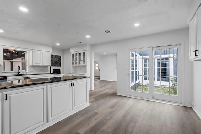 kitchen with sink, hardwood / wood-style floors, white cabinets, and tasteful backsplash