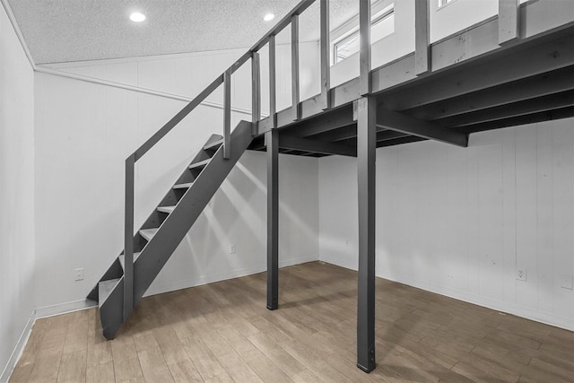 basement featuring hardwood / wood-style flooring and a textured ceiling