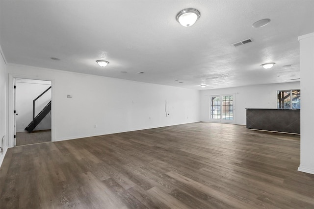 empty room with a textured ceiling and dark hardwood / wood-style floors