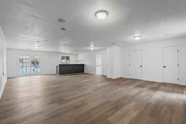 unfurnished living room with wood-type flooring and a textured ceiling