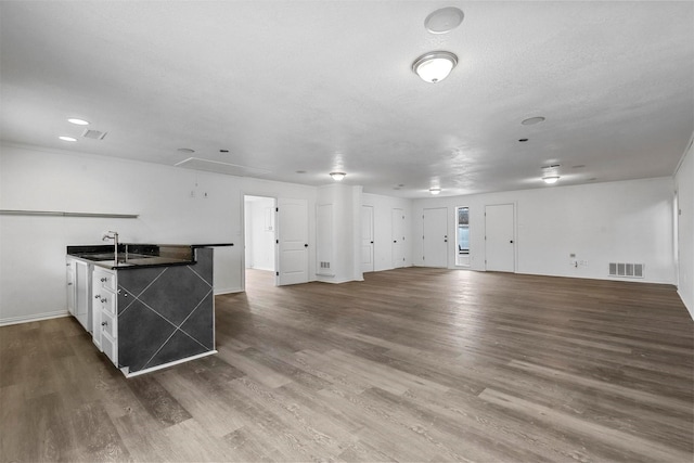 interior space featuring a textured ceiling, sink, white cabinetry, and dark hardwood / wood-style flooring