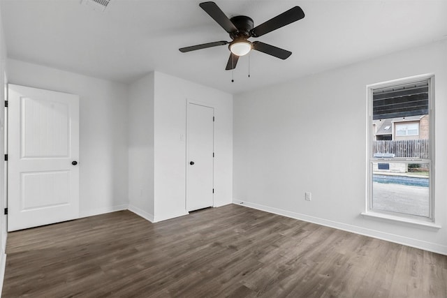 unfurnished bedroom featuring ceiling fan, dark hardwood / wood-style flooring, and a closet