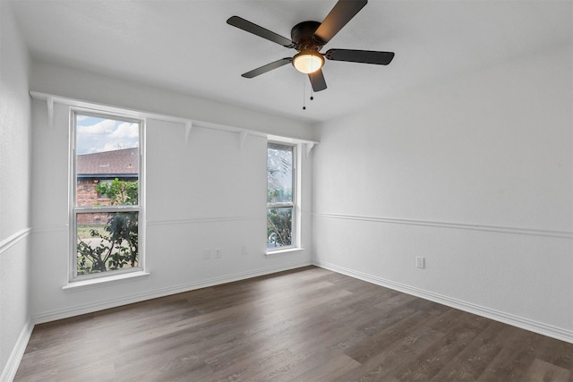 empty room featuring ceiling fan, plenty of natural light, and dark hardwood / wood-style flooring