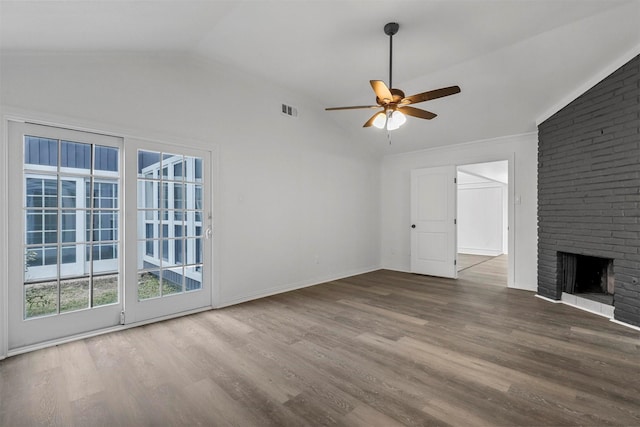 unfurnished living room with vaulted ceiling, a brick fireplace, ceiling fan, and wood-type flooring