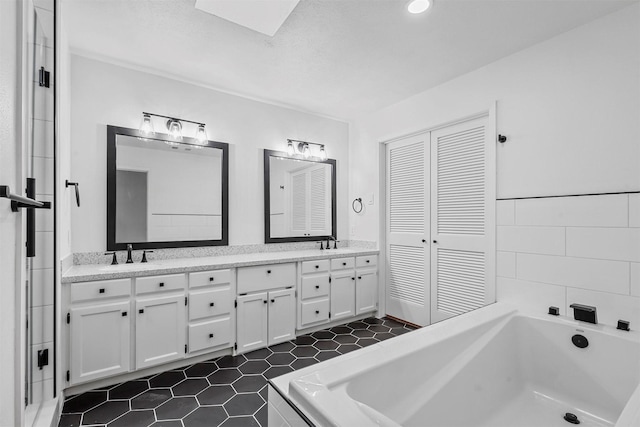 bathroom featuring tiled tub and vanity