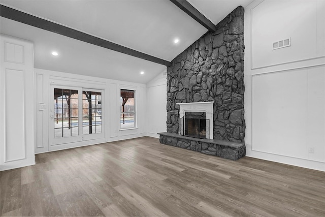 unfurnished living room featuring a fireplace, hardwood / wood-style floors, and lofted ceiling with beams