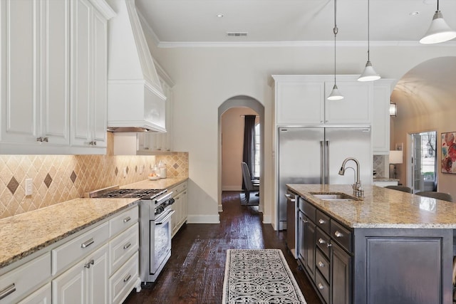 kitchen featuring white cabinetry, appliances with stainless steel finishes, a center island with sink, and pendant lighting