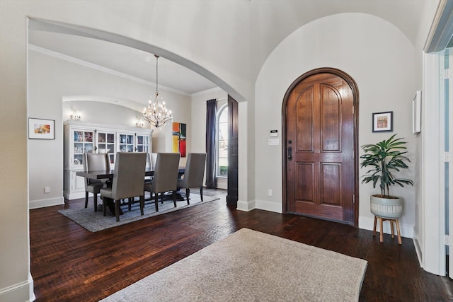 entryway with dark hardwood / wood-style flooring, a notable chandelier, and crown molding