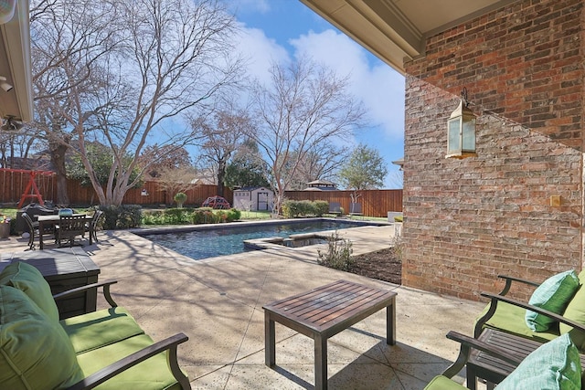 view of pool featuring a shed, an outdoor living space, and a patio area