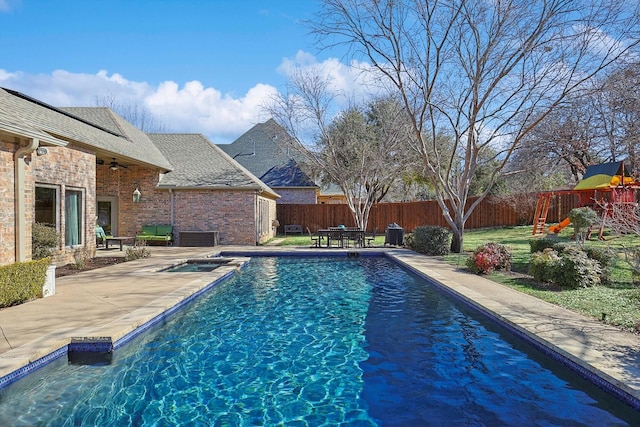 view of swimming pool featuring a playground and a patio