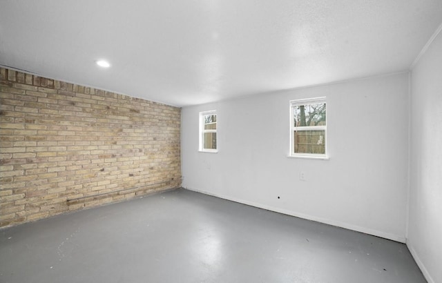 empty room featuring brick wall and concrete flooring