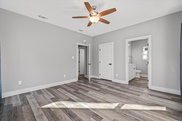 unfurnished bedroom featuring ceiling fan, light hardwood / wood-style floors, and connected bathroom