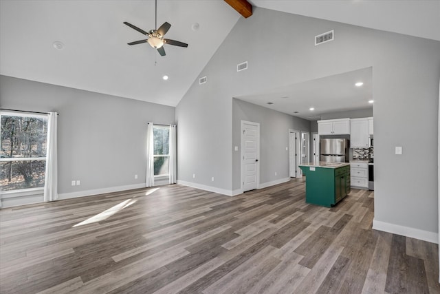 unfurnished living room with ceiling fan, high vaulted ceiling, beamed ceiling, and light hardwood / wood-style flooring