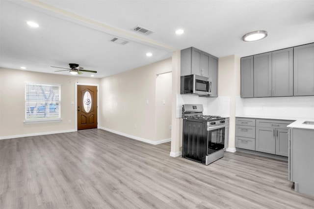 kitchen featuring ceiling fan, appliances with stainless steel finishes, gray cabinetry, and light hardwood / wood-style flooring