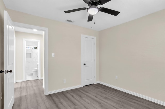 unfurnished bedroom featuring ceiling fan, connected bathroom, and light hardwood / wood-style flooring