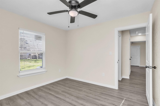 unfurnished room featuring ceiling fan, a wealth of natural light, and light hardwood / wood-style floors