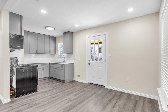 kitchen featuring decorative backsplash, gray cabinetry, and a wealth of natural light