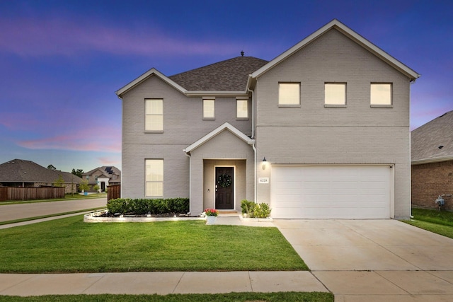 view of property featuring a garage and a lawn