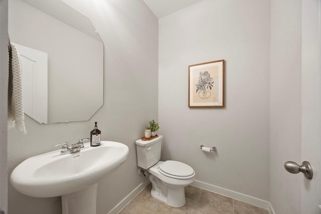 bathroom featuring sink, toilet, and tile patterned flooring