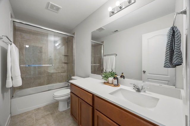 full bathroom with vanity, toilet, bath / shower combo with glass door, and tile patterned floors