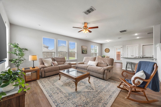 living room featuring ceiling fan and hardwood / wood-style floors