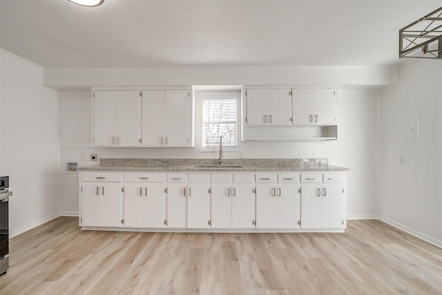 kitchen featuring sink, light hardwood / wood-style flooring, and white cabinets