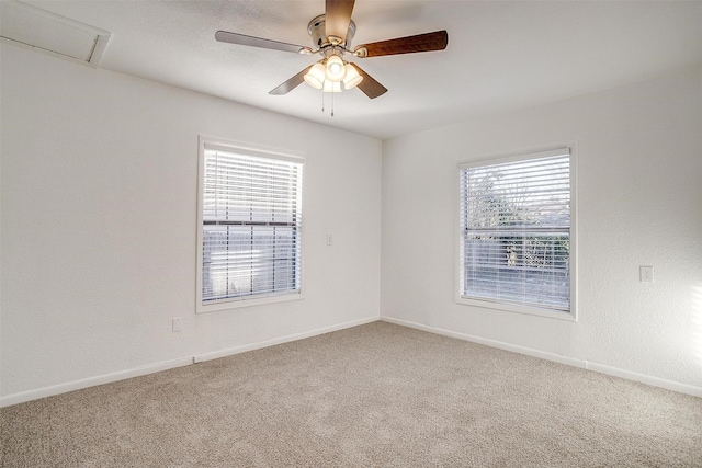 carpeted spare room featuring ceiling fan