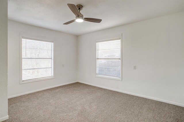 empty room with ceiling fan and carpet flooring