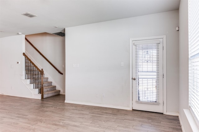 unfurnished room featuring plenty of natural light and light wood-type flooring