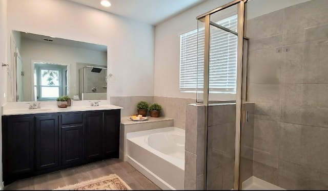 bathroom with shower with separate bathtub, vanity, and hardwood / wood-style floors