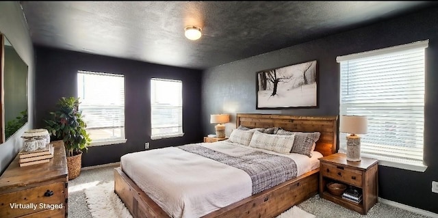 bedroom featuring a textured ceiling and light carpet