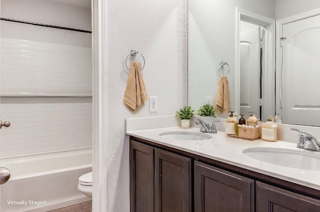 bathroom featuring toilet, a bathtub, and vanity