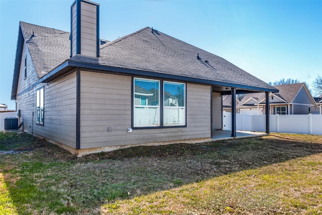 rear view of house with central AC unit, a yard, and a patio area